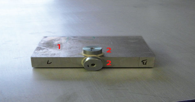 Obr. 1A Delený materiál a jeho upevnenie na stroji (1 – obrobok AISI 304, 2 – snímače vibrácií PCB IMI 607 A11, 3 – deliaca hlavica, 4 – prítlačné platne na stabilizáciu obrobku)