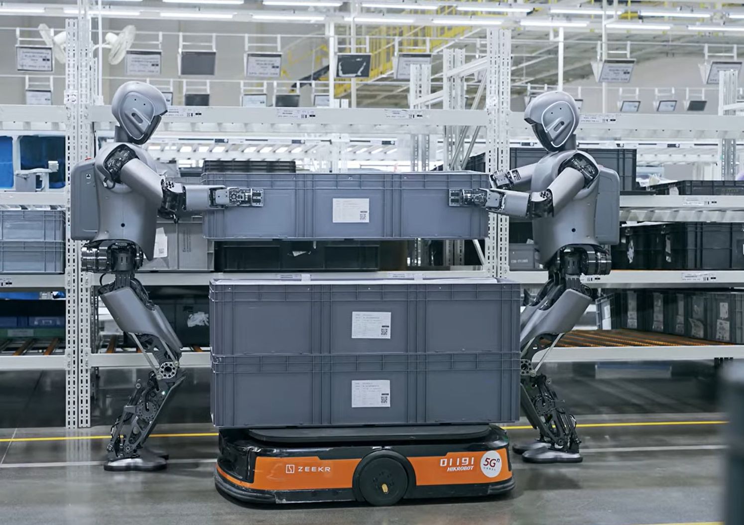 Obr. 3 Dva spolupracujúce humanoidné roboty Walker S dokážu bezproblémovo spolupracovať pri plnení úloh s autonómne navádzanými vozíkmi (Foto: (c) UBTECH Robotics, Geely Holding Group)